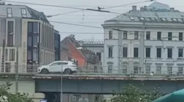 Rīdzinieki uz pauzes. Centrā mašīna pārvietojas pār dzelzceļa tiltu